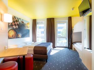 斯图加特B&B Hotel Stuttgart-Zuffenhausen的酒店客房设有两张床和电视。
