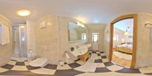 维尔德科格尔山麓布兰贝格Haus Weyerbach Apartments的一间带大镜子和 ⁇ 板地板的浴室