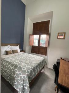瓜达拉哈拉Quinta La Perla的一间卧室设有一张床、一个窗口和一张桌子