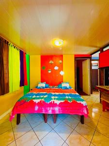 AfareaituTeraupoo Lodge Maison的一间卧室配有一张带彩色墙壁的床