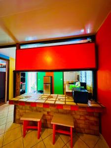 AfareaituTeraupoo Lodge Maison的一间酒吧,设有两个长椅和红色绿色的墙壁