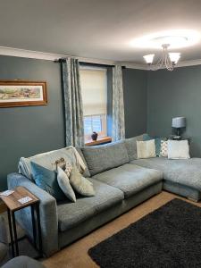 斯基普西Ivy House, three bed cottage, parking garden的客厅设有灰色的沙发和窗户。