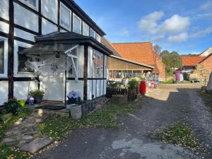 HalleTipi Zelt auf dem Ponyhof Roos的一座黑白的旧建筑,设有门廊