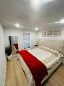 伦敦Holiday home with all season Swim spa & Pond view的一间卧室配有一张带红色毯子的大床
