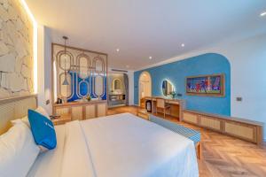 头顿V Boutique Hotel - Complimentary refreshments的一间卧室设有一张大床和蓝色的墙壁