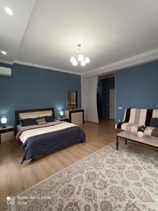 阿克套Однокомнатные апартаменты в золотом квадрате ЖК GREEN PLAZA的一间卧室设有一张床和蓝色的墙壁