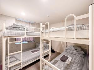 大邱Dongseongro ZERO guesthouse的一间设有三张双层床的客房