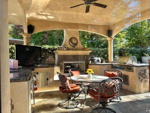 Cameron ParkTuscany Dorado Resort的户外庭院设有桌子和壁炉