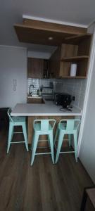 圣地亚哥Hermoso y cómodo departamento的厨房配有一张桌子和两张凳子