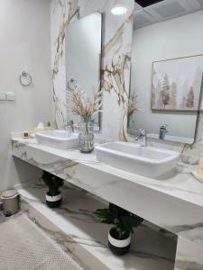 八田Sheema Lodge的浴室设有2个水槽和2面镜子