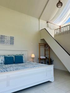 Ban Pha Saiนอนนิ่ง อิงดาว的一间白色的卧室,配有床和楼梯