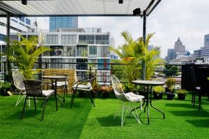 曼谷Chill apartment with unique design @ Silom Soi 3的草地上带桌椅的庭院