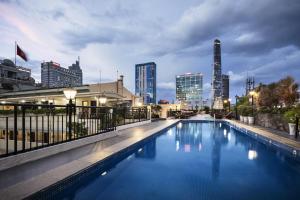 胡志明市雷克斯酒店的一座大型游泳池,其背景是城市天际线