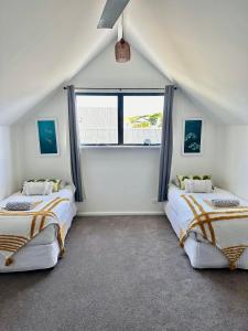 格纳拉巴普Ombak Beach Villa ~ Margaret River的带窗户的客房内的两张床