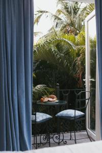 巴加嘉年华海滩住宿加早餐旅馆的阳台配有两把椅子和一张带一盘食物的桌子。