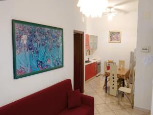 葛伦坦马勒Grottammare mon amour Kira的客厅配有红色的沙发和墙上的绘画