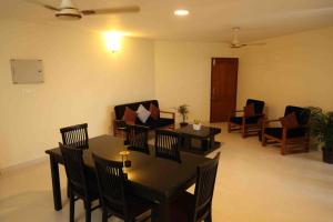 埃尔讷古勒姆Best Serviced Apartments in Cochin Marine drive的客厅配有桌椅和沙发