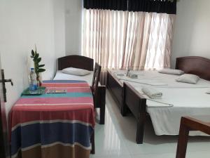 波隆纳鲁沃Senanayaka Holiday Inn的客房设有两张床和窗户。