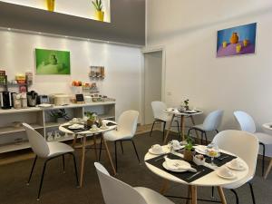 卡塞塔Zeta Rooms的用餐室配有桌子和白色椅子
