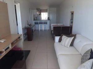 阿拉卡蒂Apart Canoa Quebrada vista mar- condominio fechado的一间带白色沙发的客厅和一间厨房