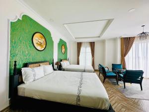 金瓯Khách Sạn The One Hotel 1的一间卧室设有两张床和绿色的墙壁