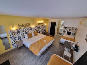 MédisCit'Hotel Les Atlantes的酒店客房,设有两张床和一张沙发