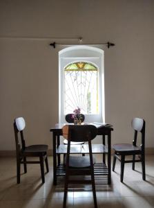 瓦加托Tien B&B & Bistro的餐桌、两把椅子和窗户