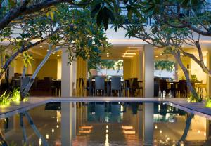 库塔桑提卡库塔酒店的酒店大堂的游泳池,配有桌椅