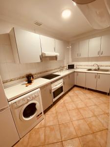 马拉加Vivienda 2 dormitorios Churriana-Aeropuerto的厨房配有白色橱柜和一台洗衣机