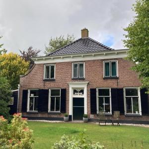 VledderDe Lindehoeve Appartement de Pompestraat的黑色屋顶红砖房子