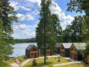 KalinowoDomki nad jeziorem Złoty Potok的享有湖畔房屋的空中景致