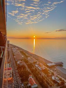 巴统Batumi VIP hotel的享有水面上日落的城市美景