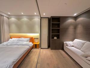 上海ZHome-Deplex luxury apartment-Near The Bund的一间卧室配有一张大床和一张沙发