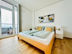 维也纳TrIIIple Level 31 - Sonnenwohnen Apartment mit fantastischem Ausblick und Parkplatz的一间卧室设有一张大床和一个大窗户