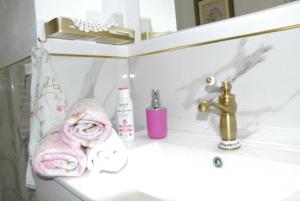 拉韦诺-蒙贝洛ViLLETTA CLAUDETTA的浴室水槽配有粉色毛巾和水龙头