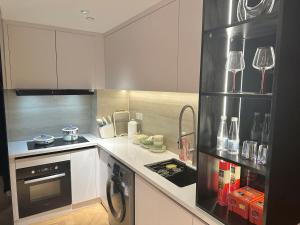 上海ZHome-Count luxury apartment的厨房配有白色橱柜和炉灶烤箱。