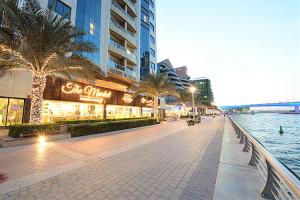 迪拜Pearl Marina Hotel Apartments的城市中一条有河流和建筑物的街道