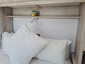 昆斯敦Mews Road Self-Catering的卧室配有白色的床和木制床头板
