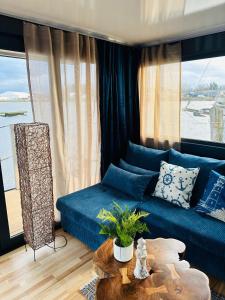 吕贝克Premium Hausboot Blaue Lagune的客厅配有蓝色的沙发和桌子