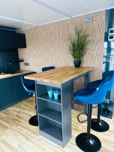 吕贝克Premium Hausboot Blaue Lagune的厨房配有一张桌子和两张蓝色凳子