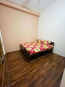 AyodhyaAshu Homestay的铺有木地板的客房内设有一间卧室和一张床。