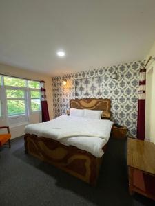 斯利那加Heritage Rose Inn的一间卧室设有一张大床和一个窗户。