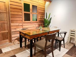 马六甲Inang Street Stay - Cheng Business Park的一间带木桌和椅子的用餐室