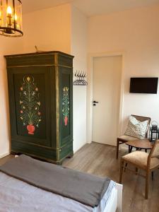 巴特多布兰Gästehaus Kleiner Wacholder的一间卧室,配有绿色橱柜和画作