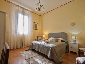 锡耶纳索奇尼别墅旅馆的一间卧室设有一张床和一个大窗户