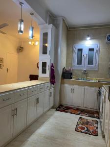 Nag` NaqshaLuxorya hotel apartment的厨房配有白色橱柜和水槽