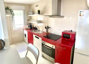 博尔穆霍斯Apartamento Liru Bormujos 2, a 5 minutos de Sevilla的红色的厨房配有水槽和微波炉