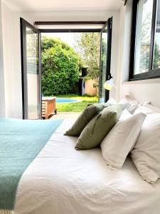 卡斯卡伊斯Design Guincho Villa的卧室配有白色的床和大窗户