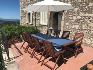 PiglioHouse near Rome with Beautiful Views and Pool的庭院内桌椅和遮阳伞