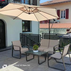 昂代Marinela的庭院配有椅子、遮阳伞和桌子。